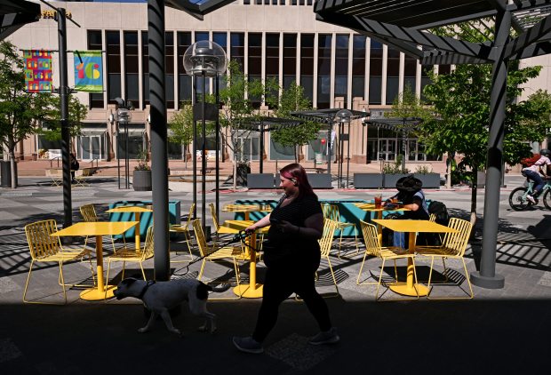A woman walks her dog down 16th Street in Denver on May 12, 2025. (Photo by Helen H. Richardson/The Denver Post)