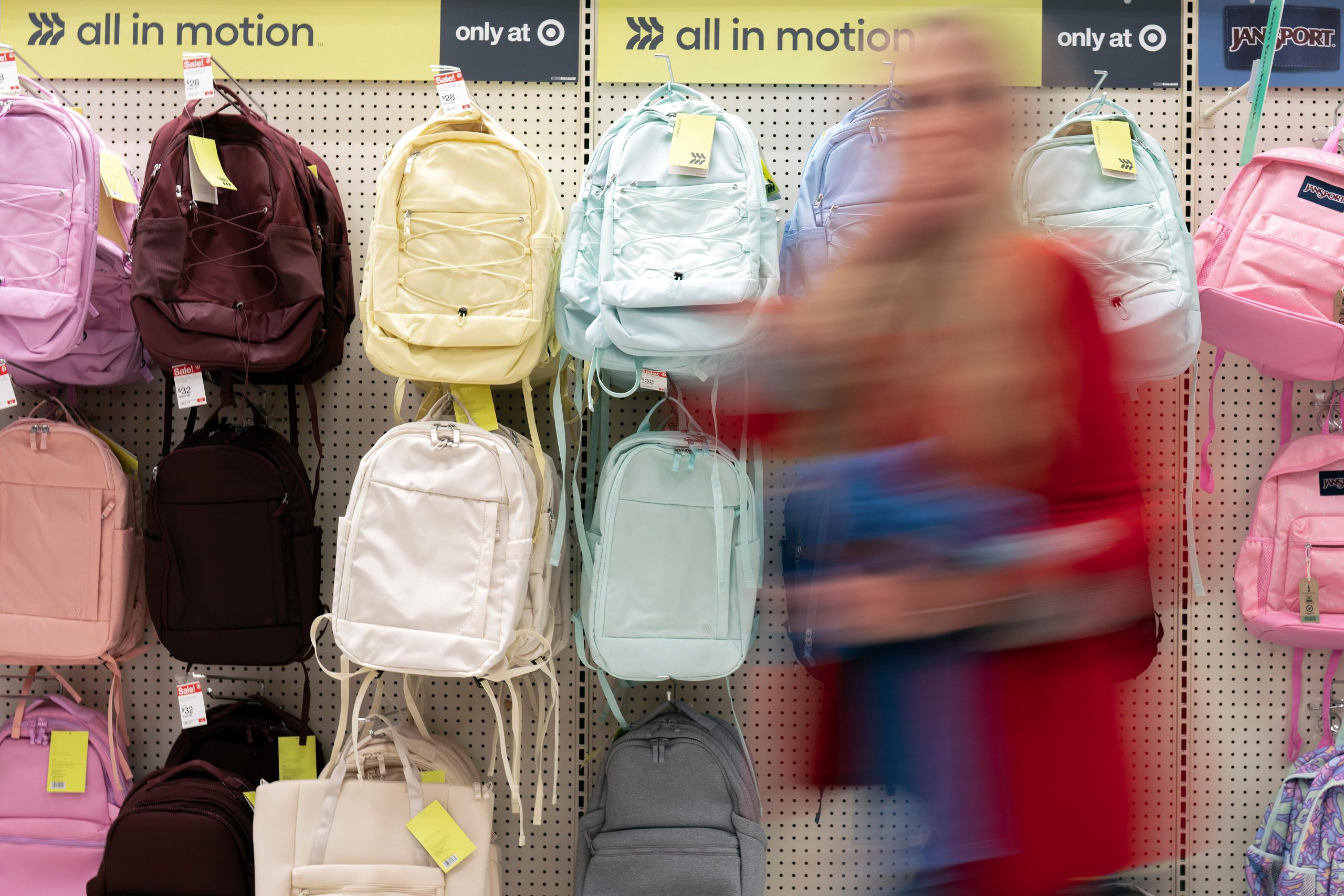 A person walks by backpacks displayed for sale in the...