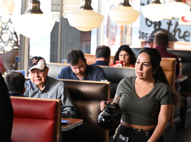 Alexis Apodaca Fresquez brings coffee to tables for refills during the breakfast rush at Sam's No. 3 diner in downtown Denver on Aug. 28, 2024. (Photo by RJ Sangosti/The Denver Post)