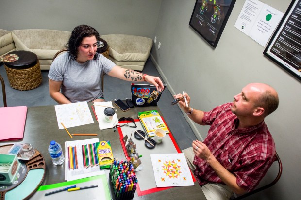 Dina and Shawn Case, of Bloomfield, Ky., exchange a vaping device at The Coffee Joint in Denver